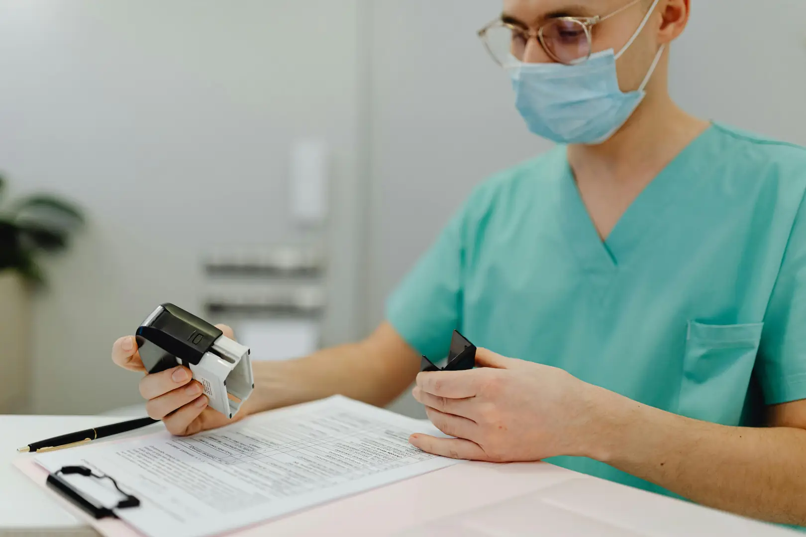 Healthcare professional reviewing compliance documents at their desk